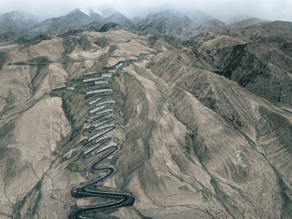 an aerial view of a winding road in the mountains